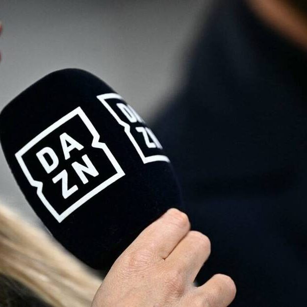 A presenter of sports streaming service DAZN holds a microphone during the Italian Serie A football match between Juventus and Cagliari, at The Allianz Stadium, in Turin on November 11, 2023. (Photo by GABRIEL BOUYS / AFP)